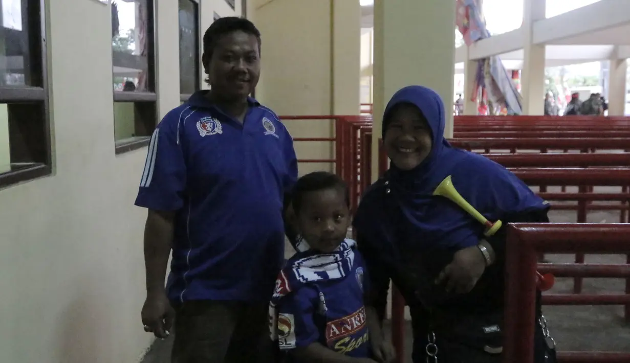 Aremania yang terdiri dari satu keluarga kecil, datang mendukung Arema di Gianyar. (Bola.com/Erwin Fitriansyah)