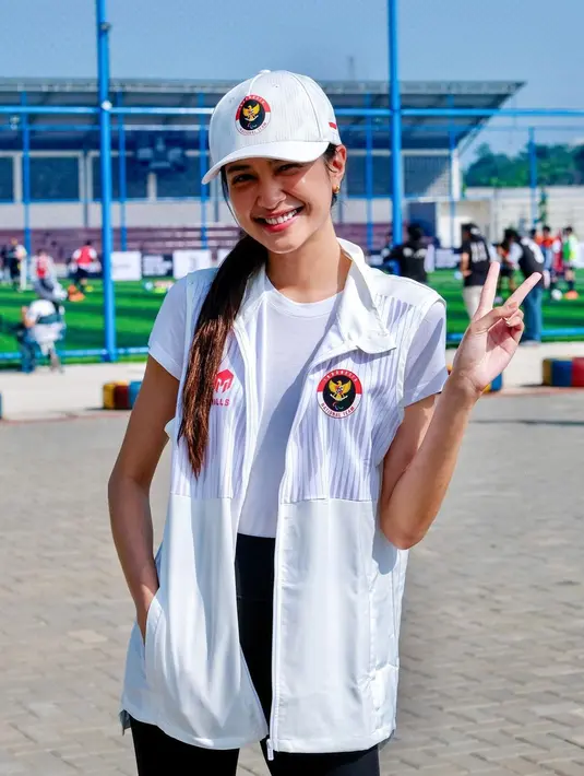 Berkunjung ke Juventus Academy Training Camp Indonesia, Mikha memadukan vest Menpora-nya dengan kaus pendek dan celana panjang.