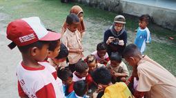 Berbaur dengan masyarakat dan anak-anak di sana, ini adalah potret Gita Savitri saat kunjungi Kepulauan Sula, Maluku Utara. YouTuber sekaligus konten kreator berusia 30 tahun ini ungkap perjalanannya yang penuh tantangan untuk tiba di tempat yang indah ini. Gita menuliskan ia harus naik ferry kurang lebih 14 jam dari Ternate, kemudian harus naik oto kira-kira 3-4 jam buat ke Desa Kabau Darat dan 2 jam ke Desa Sama. (Liputan6.com/IG/@gitasav)