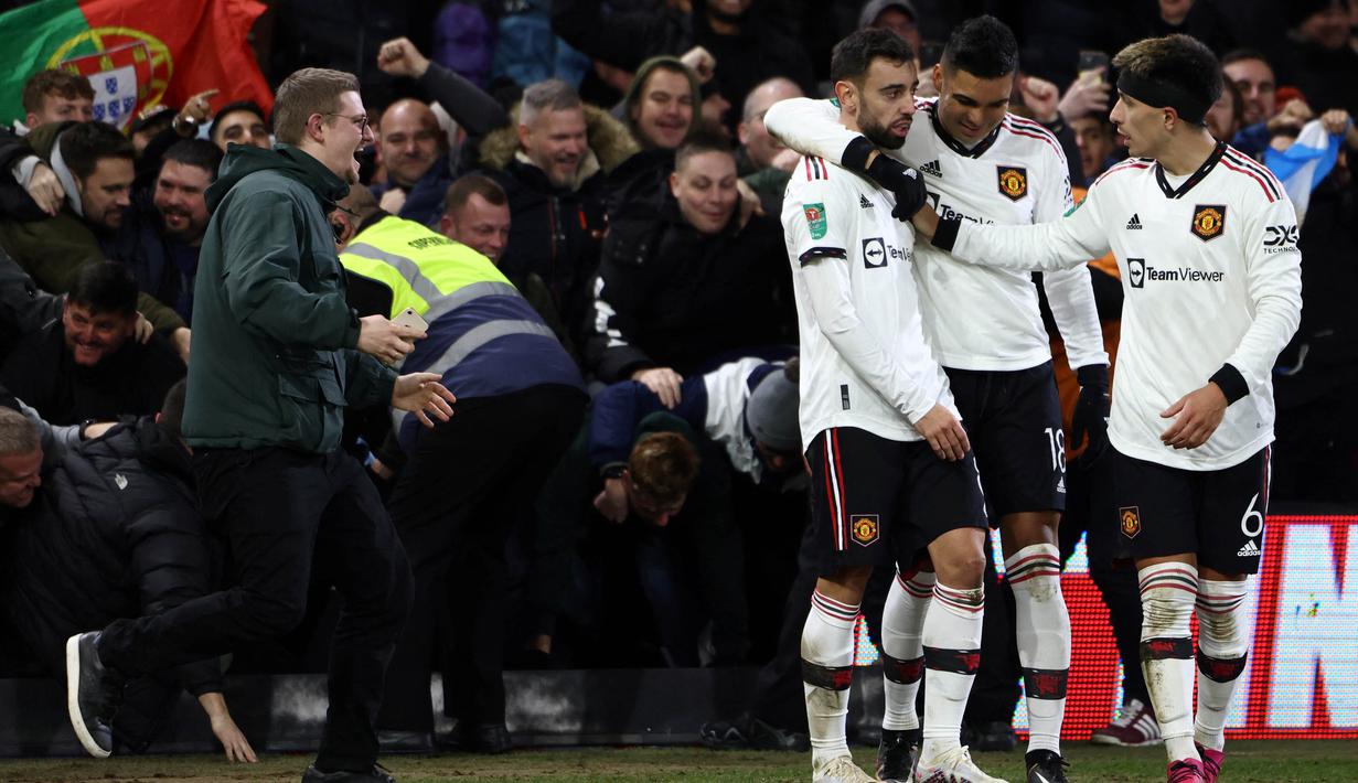 Suporter tersebut berhasil masuk lapangan dan menghampiri Bruno Fernandes, Casemiro, dan Lisandro Martinez yang berada di pinggir lapangan. (AFP/Darren Staples)