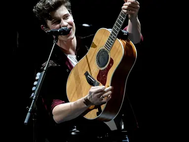 Shawn Mendes memang selalu identik dengan gitar akustik miliknya. (Liputan6.com/AFP)