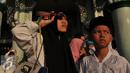 Warga menikmati proses Gerhana Matahari Total (GMT) menggunakan film bekas di halaman masjid Al-azhom Kota Tangerang, Rabu (9/3/2016). Salat gerhana tersebut diadakan sebagai ungkapan syukur atas kuasa Allah SWT. (Liputan6.com/Faisal R Syam)