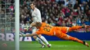 Kiper Rayo Vallecano, Yoel gagal menghalau tendangan penyerang Real Madrid, Gareth Bale pada lanjutan liga Spanyol di Santiago Bernabeu (20/12). Real Madrid menang telak atas Rayo Vallecano dengan skor 10-2. (AFP/curto DE LA TORRE)
