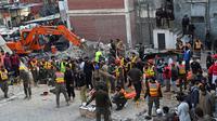 Petugas penyelamat membawa korban ledakan dari puing-puing masjid yang rusak setelah ledakan di dalam markas besar polisi di Peshawar, Pakistan, Senin (30/1/2023). Kepala polisi Peshawar, Muhammad Ijaz Khan, mengatakan kepada media lokal bahwa antara 300 hingga 400 petugas polisi berada di daerah tersebut pada saat ledakan terjadi. (Abdul MAJEED/AFP)