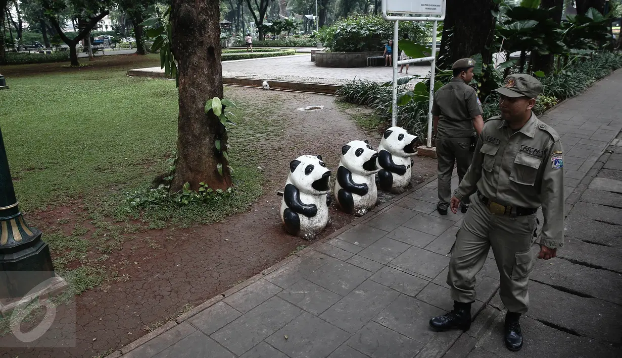 Dua petugas Satpol PP melakukan patroli di kawasan Taman Suropati, Jakarta, Selasa (14/6). Kini, Taman Suropati disterilkan dari PKL dan bersih dari parkir liar yang biasa terlihat di bahu jalan tepian taman. (Liputan6.com/Faizal Fanani)