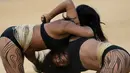Dua wanita adat sedang bergulat dalam pertandingan yang disebut Huka Huka pada Olimpiade bagi Masyarakat adat, Palmas, Brasil, (30/10/2015). Sekitar 48 etnik yang akan terdiri atas empat ribu atlet ikut dalam Olimpiade ini. (REUTERS/Ueslei Marcelino)