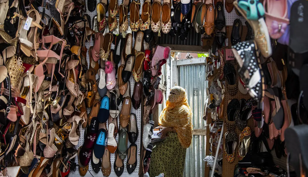 Seorang penjaga toko menata sepatu di Gauhati, India, Rabu (9/6/2021). India melonggarkan sebagian pembatasan untuk mengekang penyebaran virus corona COVID-19. (AP Photo/Anupam Nath)