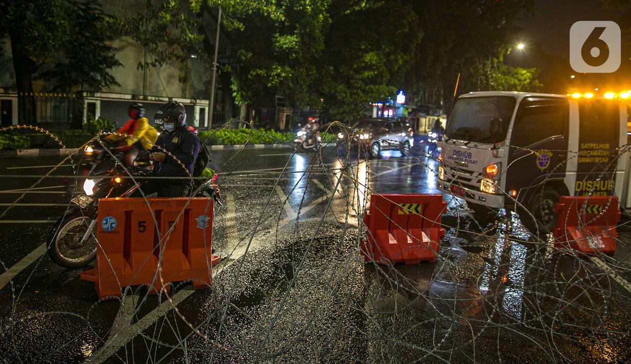 Pengendara sepeda motor mencari jalan lain saat penyekatan jalan di kawasan Pasar Baru, Jakarta, Kamis (31/12/2020). Polda Metro Jaya menutup sejumlah ruas jalan selama Car Free Night dan Crowd Free Night pada malam Tahun Baru 2021 untuk mencegah penyebaran COVID-19. (Liputan6.com/Faizal Fanani)
