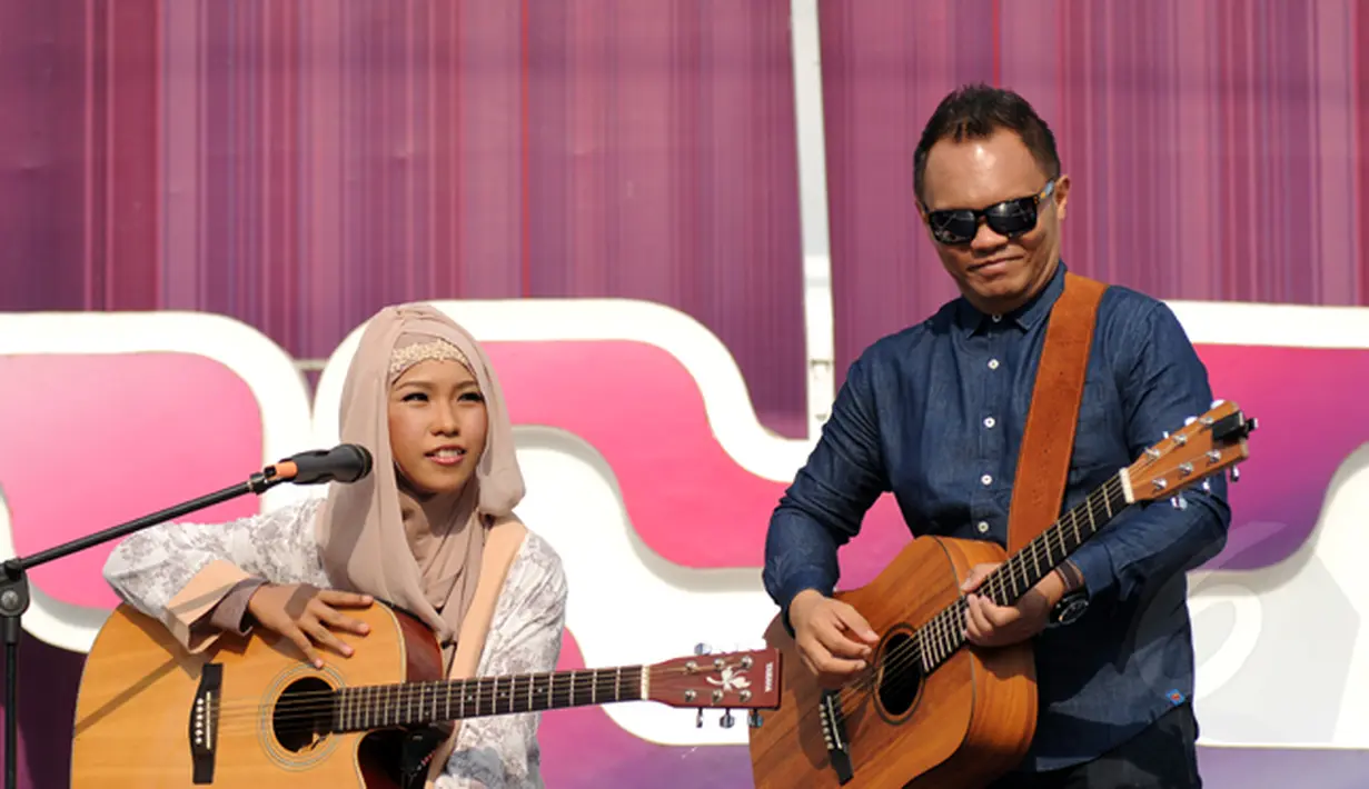 Juara Music Video Contest, Wiwi Handayani (kiri) berduet bersama Badai 'Kerispatih' di panggung inBox SCTV di Cibinong Square, Bogor, Jumat (30/1/2015). Tampak, Badai 'Kerispatih' unjuk kebolehan bermain gitar. (Liputan6.com/Helmi Fithriansyah)