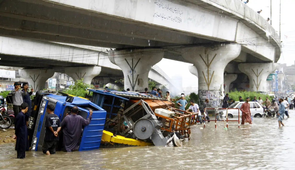 Kendaraan terguling setelah hujan monsun mengguyur deras di Kota Karachi, Pakistan, 25 Agustus 2020. Hujan deras membuat kekacauan di beberapa bagian kota tersebut, dengan air hujan menyebabkan banjir serta merendam jalan, kendaraan, maupun area-area berdataran rendah. (Xinhua/Str)