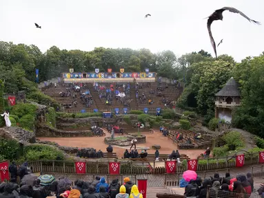 Para pengunjung menyaksikan pertunjukan di taman hiburan Puy du Fou di Les Epesses, Vendee, Prancis barat (11/6/2020). Taman hiburan Puy Du Fou dibuka kembali untuk pengunjung pada Kamis (11/6) setelah ditutup selama hampir tiga bulan karena pandemi COVID-19. (Xinhua/Jack Chan)