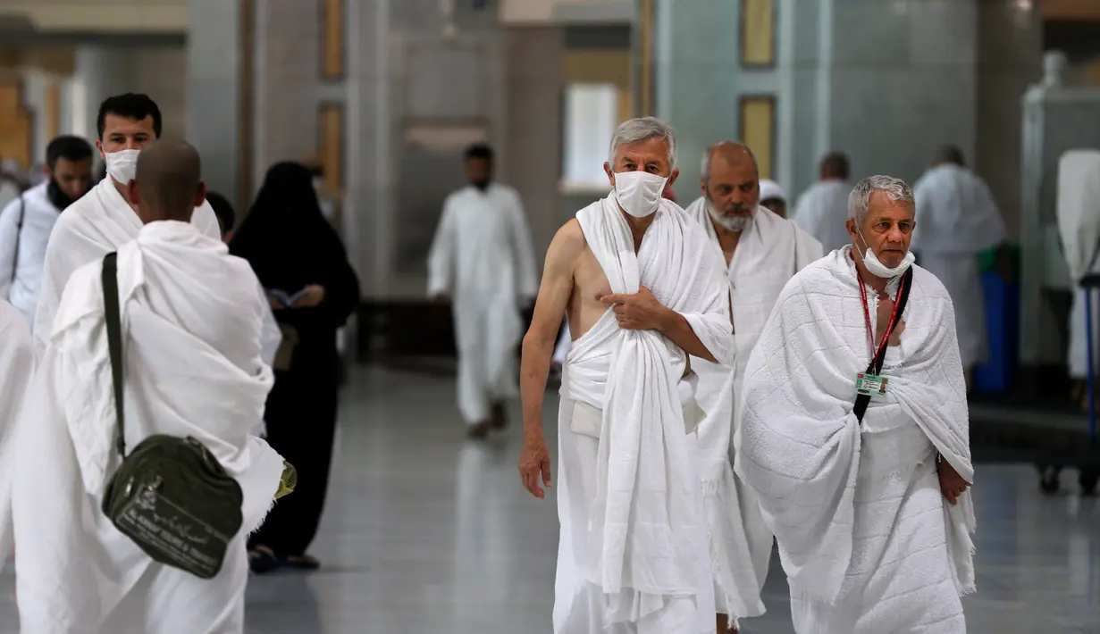 Umat Muslim mengenakan masker di Masjidil Haram, kota suci Makkah, Kamis (27/2/2020). Suasana Masjidil Haram berjalan sebagaimana biasanya pascapengumuman Pemerintah Arab Saudi melarang sementara jemaah umrah ke Tanah Suci terkait pencegahan penyebaran virus korona. (Abdulghani BASHEER/AFP)