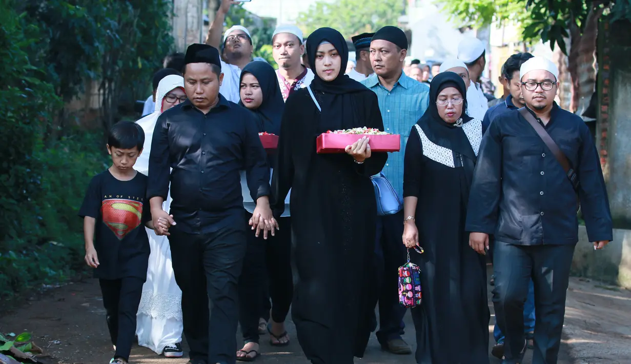 Dengan mengenakan pakaian hitam-hitam, Narji didampingi anak pertamanya dan istrinya beserta kerabatnya mengantarkan ayahnya ke peristirahatan terakhirnya di TPU Poncol tadi pagi. (Adrian Putra/Bintang.com)