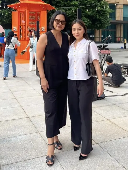 Nikita Willy tampil dengan kemeja putih lengan pendek dengan kancing keemasannya. Dipadukan celana panjang hitam serasi dengan shoulder bag dan stiletto heels. @amaliawirjono