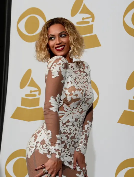 Dipenampilan sebelumnya  Beyonce tampak cantik dalam balutan atasan lengan panjang putih berenda sembari membetulkan rambutnya dengan tangan kirinya.  (Bintang/EPA)