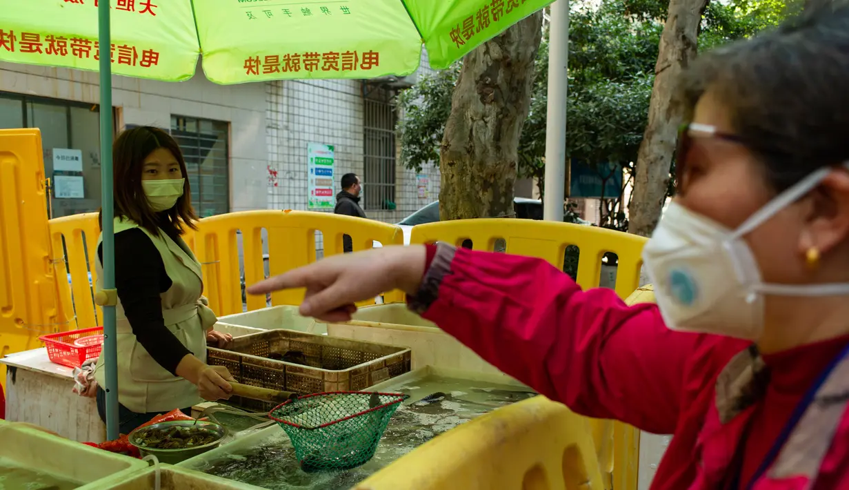 Seorang wanita membeli ikan di Wuhan, ibu kota Provinsi Hubei, China tengah, (16/4/2020). Seiring meredanya epidemi COVID-19, kehidupan berangsur kembali normal di Wuhan. (Xinhua/Shen Bohan)
