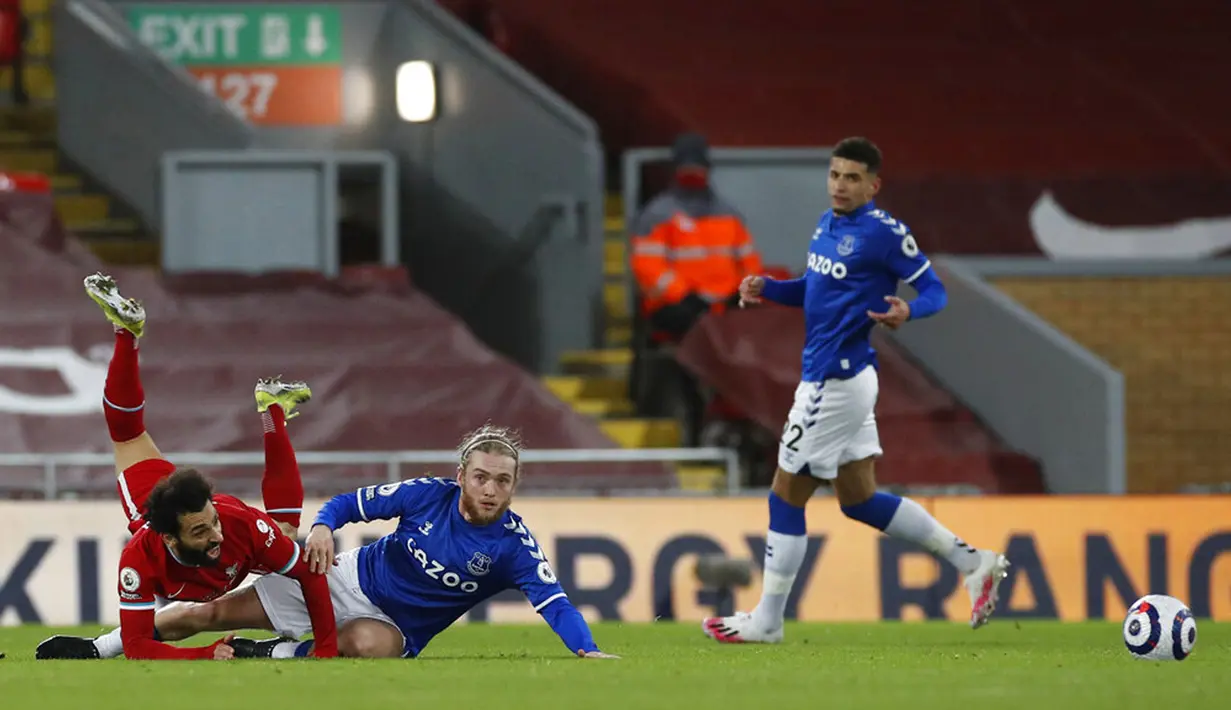 Pemain Liverpool Mohamed Salah terjatuh saat dijegal oleh pemain Everton Tom Davies pada pertandingan Liga Inggris di Anfield, Liverpool, Inggris, Sabtu (20/2/2021). Liverpool kalah 0-2. (Phil Noble/Pool via AP)