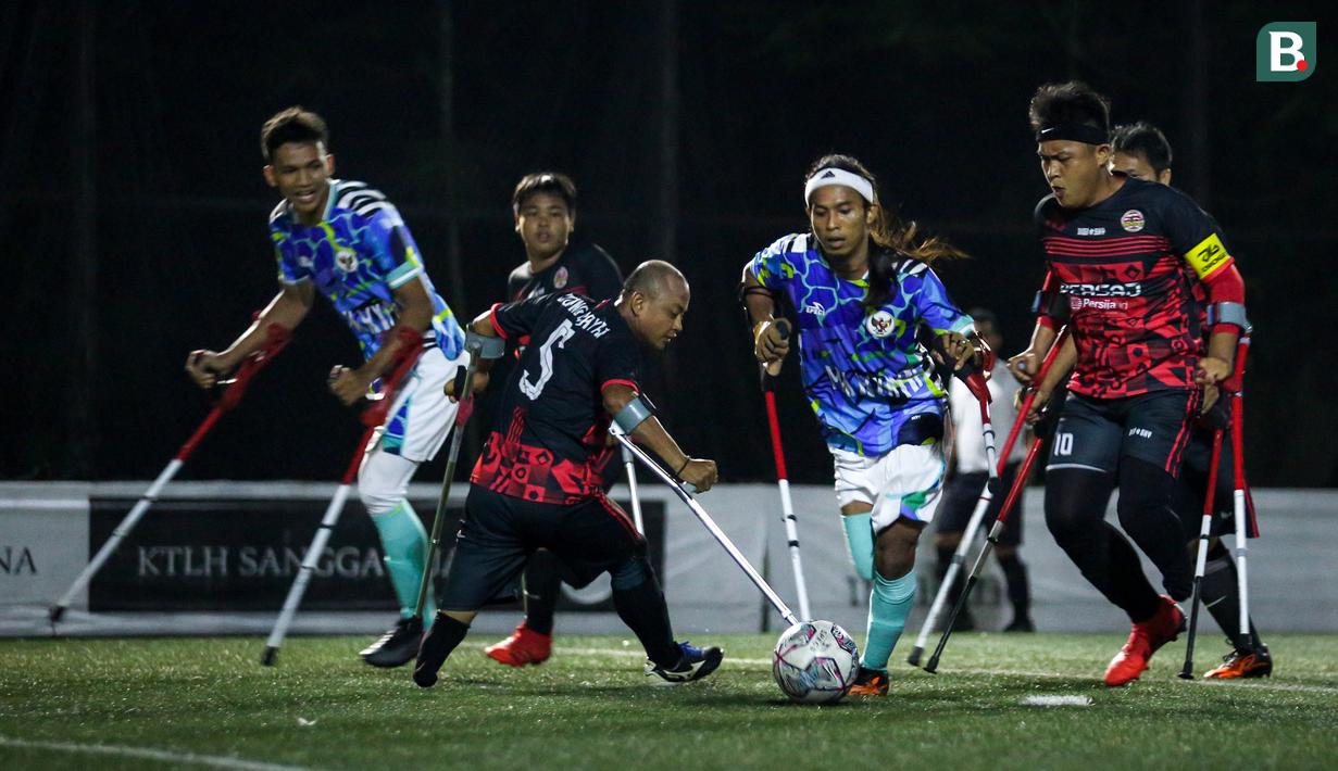 Pemain Timnas Sepak Bola Amputasi Indonesia, M. S. Bahiri (tengah) berusaha melewati pemain Persaj Jakarta saat laga uji coba untuk persiapan Piala Dunia Amputasi 2022 di Serenia Hills Mini Soccer, Jakarta Selatan, Senin (08/08/2022). Garuda INAF menang dengan skor 13-0. (Bola.com/Bagaskara Lazuardi)