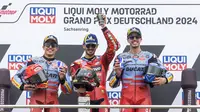 Pecco Bagnaia saat naik podium Main Race MotoGP Jerman 2024. Dia diapit Marc Marquez dan Alex Marquez. (Radek Mica / AFP)