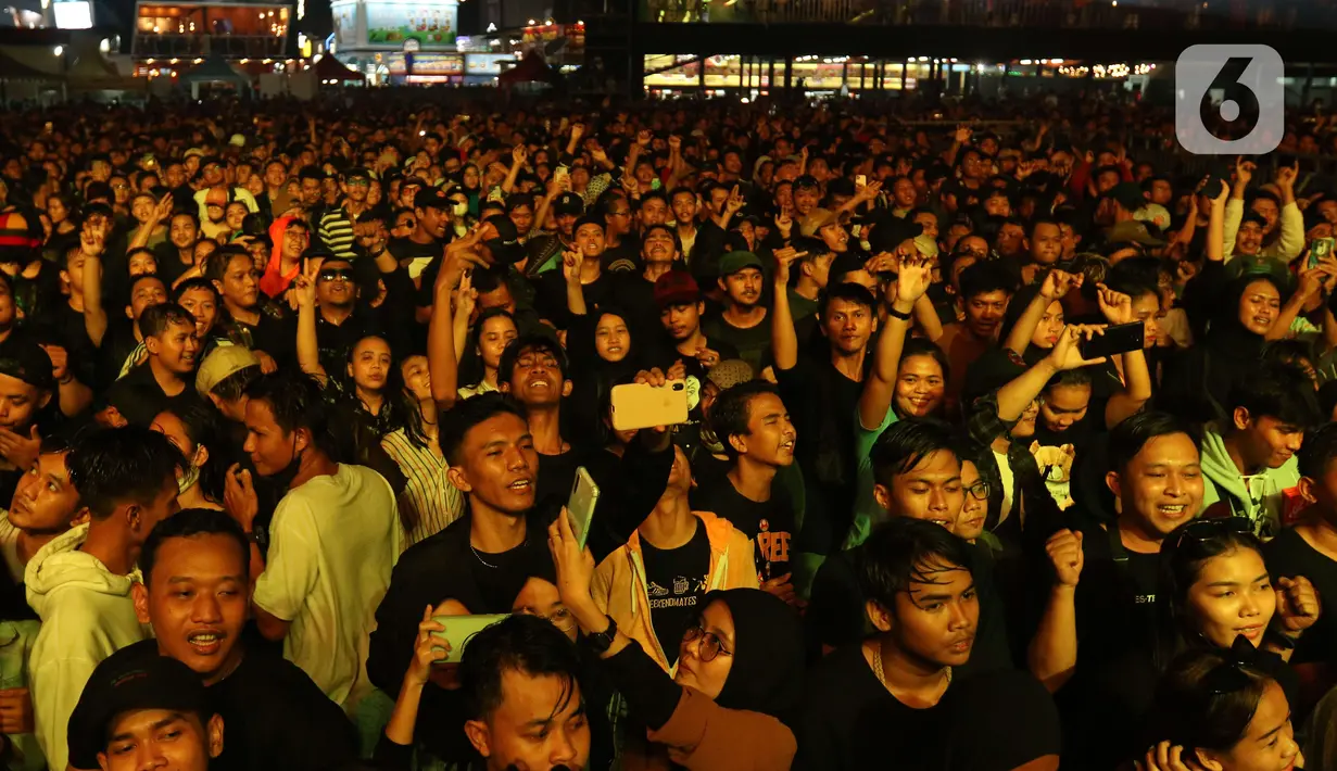 Penonton menyaksikan penampilan Souljah saat Jakarta Fair atau yang lebih dikenal dengan Pekan Raya Jakarta (PRJ) 2022 di Arena Jakarta International Expo, Kemayoran, Jakarta Pusat, Selasa (21/6/2022). Souljah adalah band musik reggae dan ska Jamaika yang berdiri sejak tahun 1998 dengan nama awal Arigato. (Liputan6.com/Herman Zakharia)