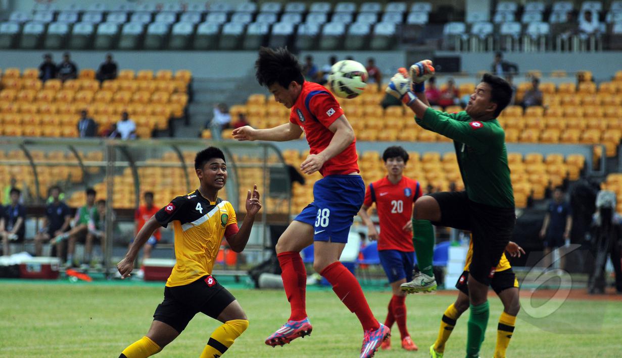 Penjaga gawang Brunei Darussalam U-23, Ahsanuddin (kanan) mencoba menghalau bola saat berlaga melawan Korea Selatan di kualifikasi grup H Piala Asia 2016 di Stadion GBK, Jakarta, Jumat (27/3/2015). (Liputan6.com/Helmi Fithriansyah)