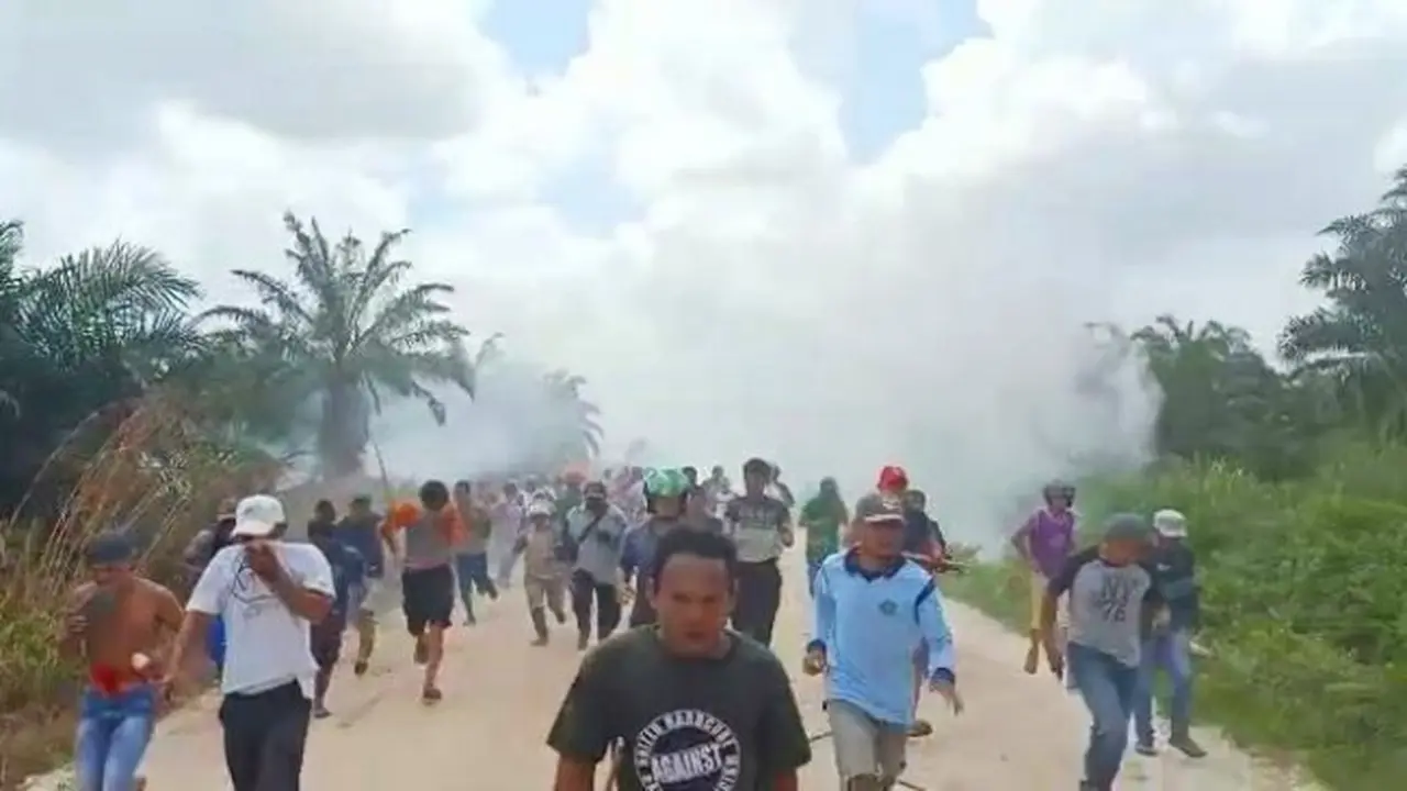Warga Desa Gondai, Kabupaten Pelalawan, berlarian menghindari tembakan gas air mata di lokasi eksekusi lahan.