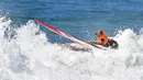 Seekor anjing berselancar di atas ombak saat kompetisi tahunan City Surf Dog di Huntington Beach, California, Sabtu (29/9). Selain solo surfing, terdapat juga tandem surfing baik dengan anjing lainnya maupun dengan pemiliknya (AFP/Frederic J. BROWN)