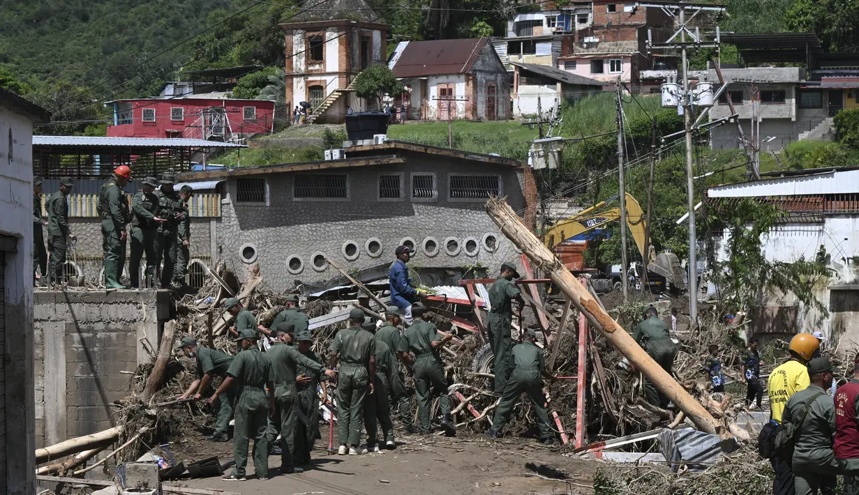 Anggota Tentara Venezuela mencari di antara puing-puing rumah yang hancur untuk mencari korban atau penyintas setelah tanah longsor saat hujan lebat di Las Tejerias, negara bagian Aragua, Venezuela, pada 10 Oktober 2022. Wakil Presiden Delcy Rodriguez mengatakan,Tanah longsor di Venezuela tengah menewaskan sedikitnya 22 orang dan banyak lagi dari 50 hilang setelah hujan lebat menyebabkan sungai meluap. (AFP/Yuri Cortez)