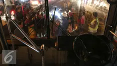 Sejumlah warga mengerumuni pria tanpa identitas yang sekarat usai di tabrak bus PPD 213 di kawasan Matraman Raya, Jakarta, Kamis (20/8/2015). Menurut saksi pria tersebut nekat menyeberang melewati jalur busway. (Liputan6.com/Faizal Fanani)