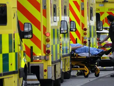 Seorang pasien didorong dengan troli setelah tiba dengan ambulans di luar Rumah Sakit Royal London, Inggris, 6 Januari 2022. Inggris memangkas waktu isolasi pasien COVID-19 dari 10 menjadi 7 hari karena kekurangan tenaga kesehatan akibat lonjakan kasus yang dipicu Omicron. (AP Photo/Matt Dunham)