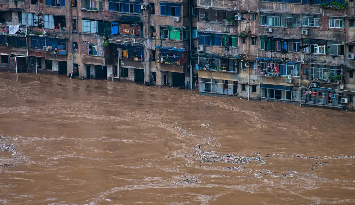Daerah permukiman yang terendam banjir di Distrik Qijiang, Kota Chongqing, China barat daya (1/7/2020). Guyuran hujan telah menyebabkan peningkatan debit air ke sungai-sungai di daerah pusat kota, dan beberapa pagar pengaman di sepanjang sungai rusak oleh derasnya arus air. (Xinhua/Chen Xingyu)