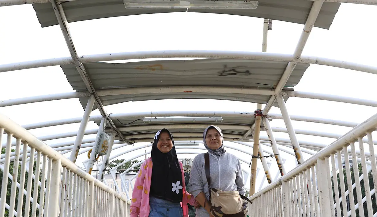 Pejalan kaki melintasi jembatan penyeberangan orang (JPO) Jayakarta yang atapnya rusak dan hilang di Menteng, Jakarta, Jumat (11/1). Kondisi JPO yang rusak mengganggu kenyamanan pejalan kaki. (Liputan6.com/Immanuel Antonius)