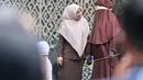 Seorang petugas penegak hukum berbicara dengan petugas syariat saat seorang perempuan sedang menjalani hukuman cambuk di Banda Aceh,  Kamis, 20 Agustus 2026. (AFP/ Chaideer Mahyuddin)