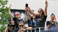 Pemain timnas sepak bola wanita Amerika Serikat (AS), Megan Rapinoe (kiri belakang) dan Alex Morgan (depan kanan) bersama rekan-rekan mereka menyapa warga saat parade kemenangan Piala Dunia Wanita 2019 di New York, AS, Rabu (10/7/2019). (AP Photo/Craig Ruttle)