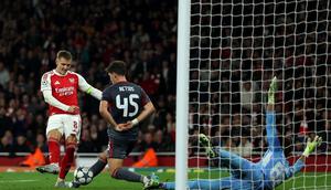 Gelandang Arsenal asal Norwegia, Martin Odegaard, menembak bola ke gawang Olimpiakos tetapi gagal pada pertandingan Liga Champions di Stadion Emirates, London, Kamis (2/10/2025) dini hari WIB. (Adrian Dennis / AFP)
