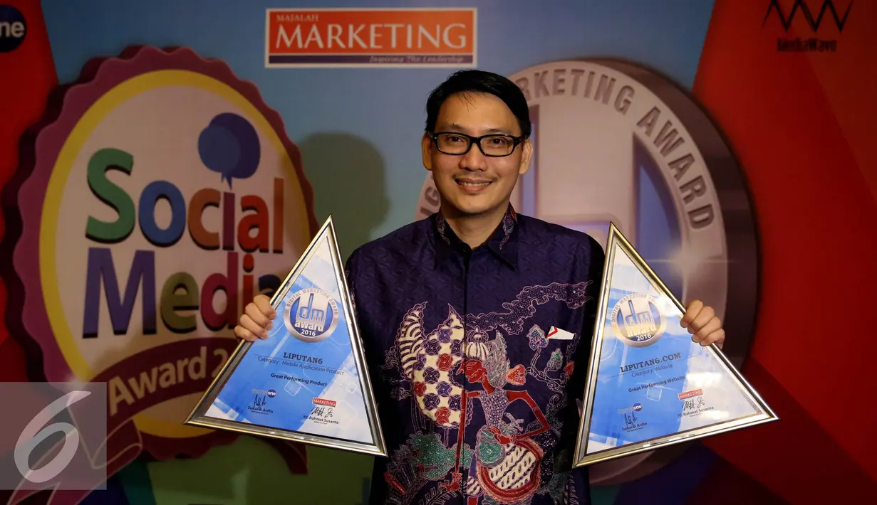 COO PT KMK, Manuel Irwanputra berpose dengan tropi The Best Digital Product kategori “News & Magazine App” dan The Best Website kategori “Situs Berita” di acara Digital Marketing Award 2016, Jakarta, Kamis (19/10). (Liputan6.com/Johan Tallo)