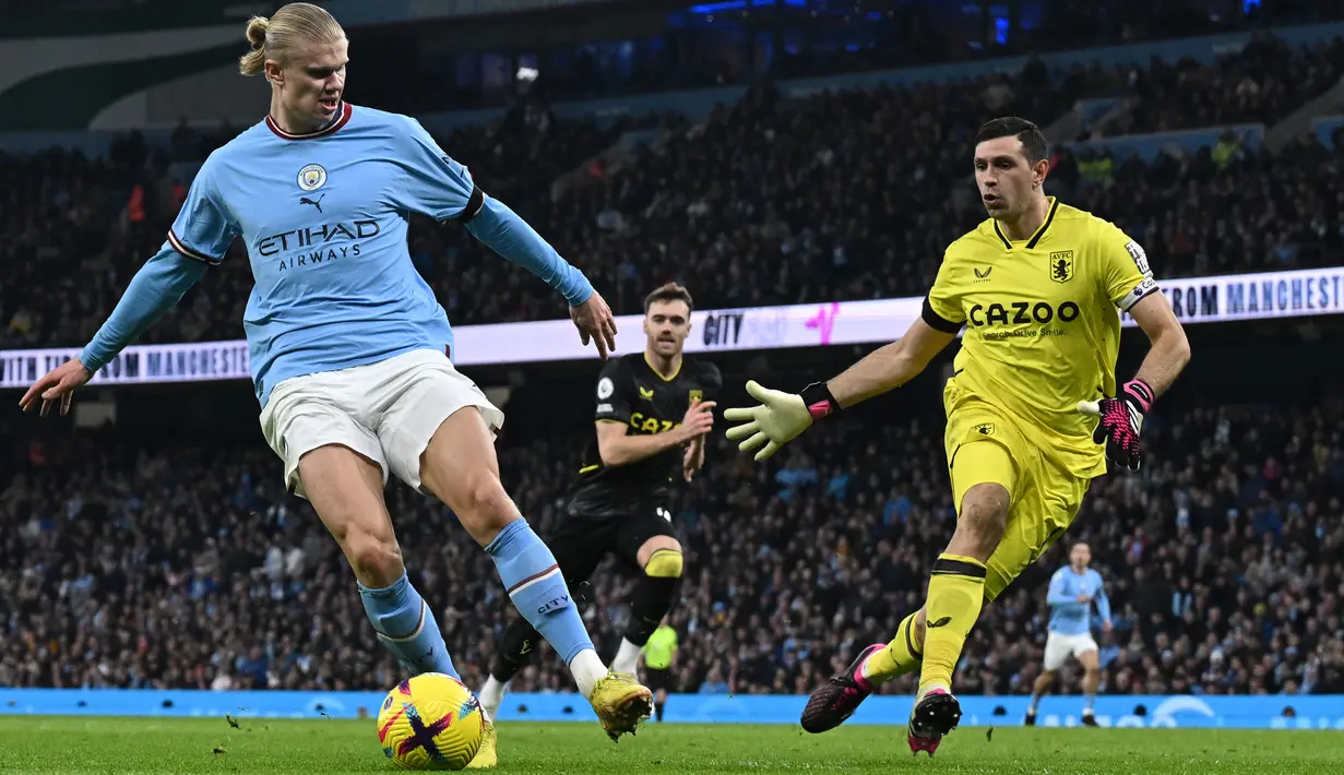 <p>Penyerang Manchester City, Erling Haaland mengontrol bola dari kawalan kiper Aston Villa, Emi Martinez selama pertandingan lanjutan Liga Premier Inggris di Stadion Etihad di Manchester, barat laut Inggris (13/2/2023). City menang telak atas Aston Villa dengan skor 3-0. (AFP/Paul Ellis)</p>