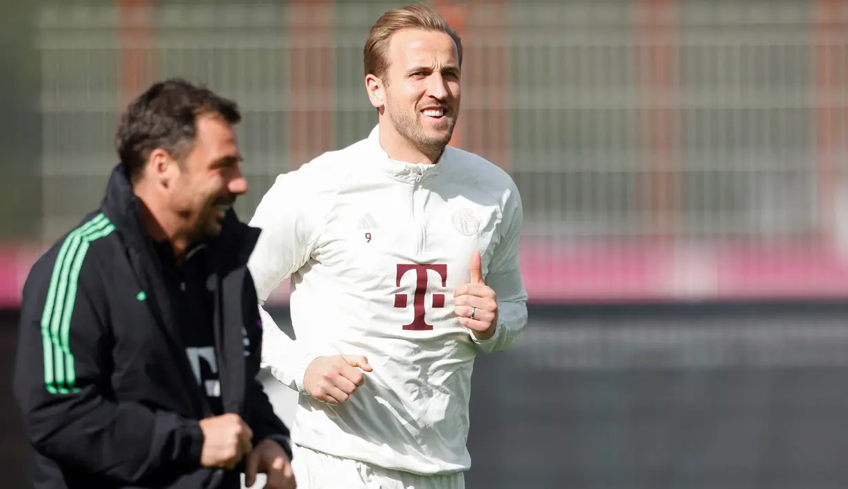 Pemain depan Bayern Munchen #09 Harry Kane (kanan) dan asisten pelatih Zsolt Loew menghadiri sesi latihan menjelang leg kedua perempat final Liga Champions 2023/2024 di Stadion Allianz Arena di Munich, Selasa (16/4/2024). (Michaela STACHE / AFP)