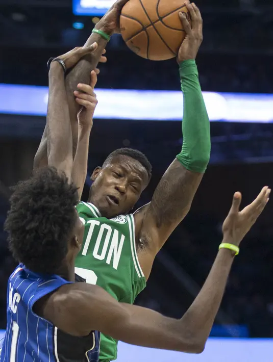 Pebasket Boston Celtics, Tony Rozier, berebut bola dengan pebasket Orlando Magic, Jonathan Isaac, pada laga NBA di Amway Center, Orlando, Minggu (5/11/2017). Magic kalah 88-104 dari Celtics. (AP/Willie J Allen Jr)