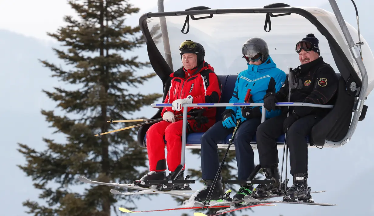 Presiden Rusia Vladimir Putin (kiri) dan Presiden Belarusia Alexander Lukashenko (kanan) menaiki lift ski saat akan bermain ski di Krasnaya Polyana dekat resor Laut Hitam Sochi, Rusia, Rabu (13/2). (Sergei Chirikov/Pool Photo via AP)