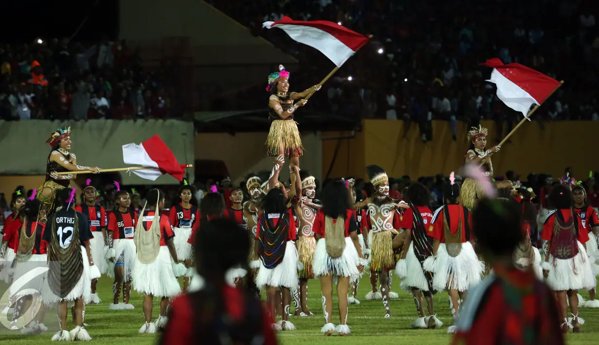 Penari mengibarkan bendera Merah Putih saat pembukaan Torabika Soccer Championship presented by IM3 Ooredoo di Stadion Mandala Jayapura, Papua, Jumat (29/4/2016). Laga perdanamempertemukan Persipura vs Persija. (Liputan6.com/Helmi Fithriansyah)