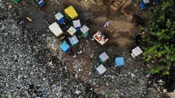 Pandangan udara menunjukkan seorang pria berjalan di samping becak yang diparkir di dekat saluran pembuangan air limbah yang dipenuhi sampah di lingkungan berpenghasilan rendah di New Delhi, India (4/10/2019). (AFP Photo/Noemi Cassanelli)