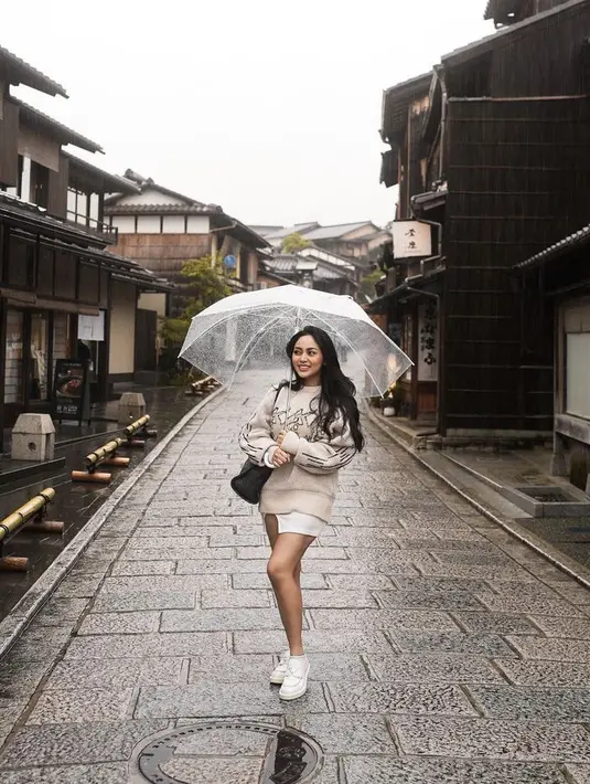 Rachel memadukan oversize sweater dengan mini skirt berdetail belahan warna putih, serasi dengan sepatu Pradanya. (@rachelvennya)