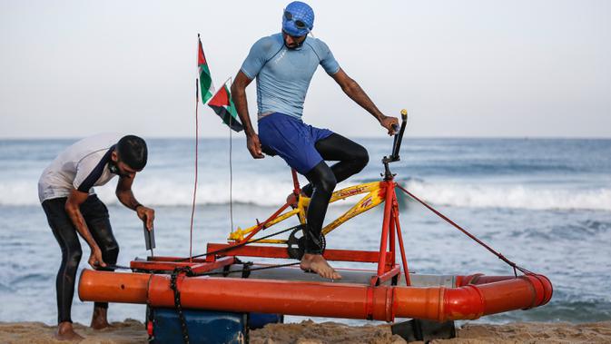 Nelayan Palestina menguji perahu kayuh yang dibuat khusus dari bahan daur ulang di sepanjang pantai di Beit Lahia, Jalur Gaza pada 29 September 2020. (Photo by MOHAMMED ABED / AFP)