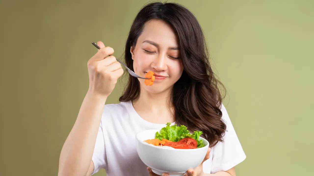 perempuan memakan sayuran untuk kesehatan