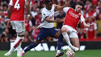 Gelandang Arsenal, Declan Rice (kanan) mendapatkan penjagaan ketat dari bek kiri Tottenham Hotspur, Destiny Udogie dalam Derbi London Utara di Premier League 2023/2024, Minggu (24/9/2023) malam WIB. (AFP/Henry Nicholls)