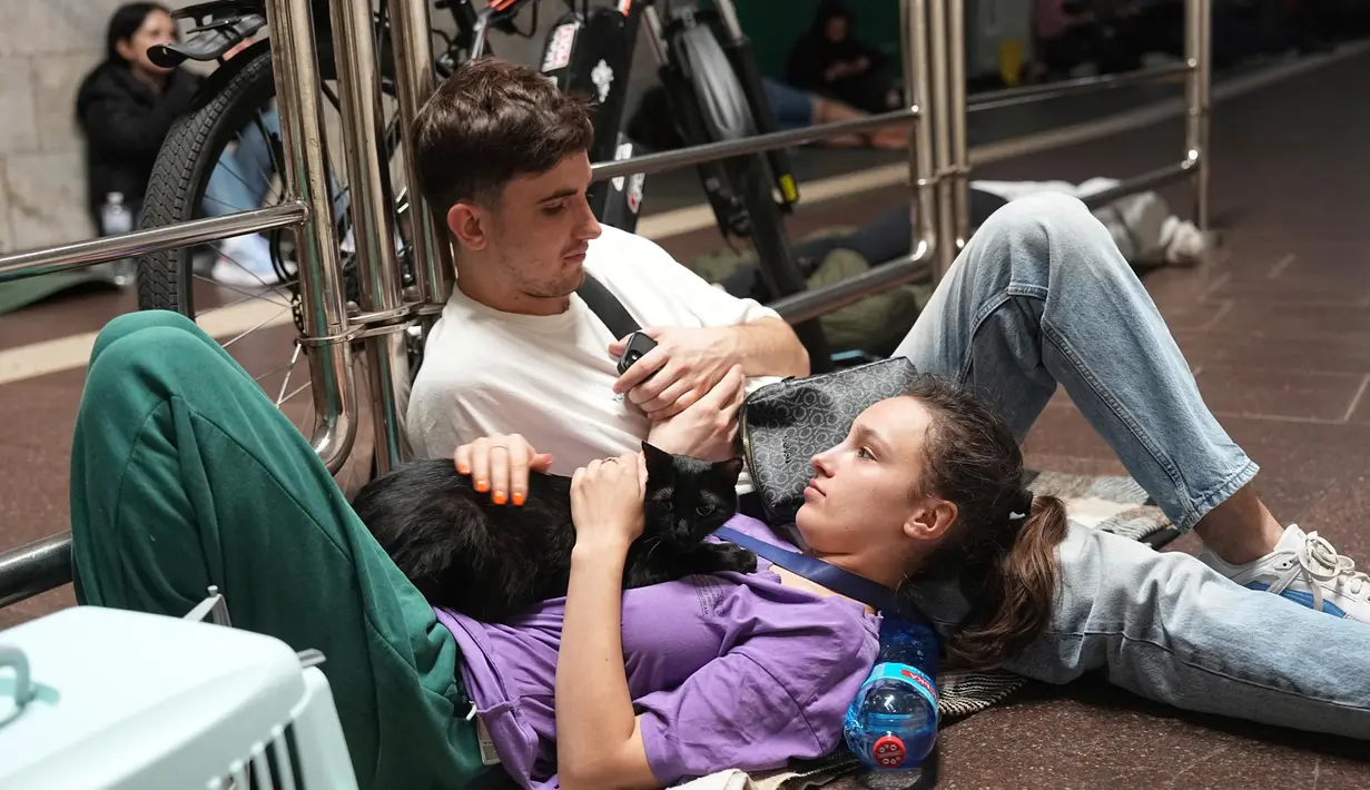 Puluhan warga Kyiv memilih berlindung di dalam stasiun kereta bawah tanah, mereka membawa alas tikar dan barang berharga lainnya untuk beristirahat sambil menunggu serangan selesai. (AP Photo/Efrem Lukatsky)