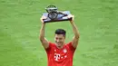 Pemain Bayern Munchen, Robert Lewandowski, mengangkat trofi pencetak gol terbanyak Bundesliga 2019 di Allianz Arena, Jerman, Sabtu (18/5).  Munchen menang 5-1 atas Frankfurt. (Sven Hoppe/dpa/AFP).