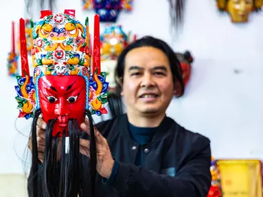 Zhou Ming, pewaris tradisi seni ukir kayu Anshun, menunjukkan topeng Dixi di Anshun, Provinsi Guizhou, China, 27 November 2020. Dixi, sebuah opera lokal di Anshun, telah terdaftar sebagai salah satu warisan budaya takbenda nasional China. (Xinhua/Chen Xi)