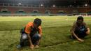 Pekerja merapihkan rumbut sintetis saat persiapan jelang laga semifinal Piala AFF 2016 antara Timnas Indonesia melawan Vietnam di Stadion Pakansari, Jawa Barat, Jumat (3/12/2016). (Bola.com/Vitalis Yogi Trisna)